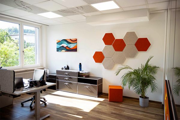 kleines B&uuml;ro mit sechseckigen Schallabsorbern und einem Akustikbild an der Wand